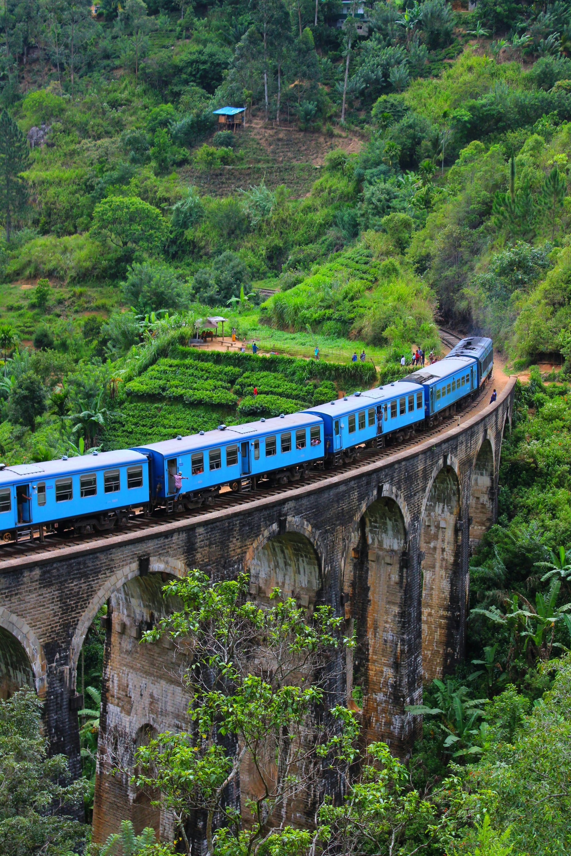 Nine Arch Bridge Ella with blue Upcountry Line train — portrait view