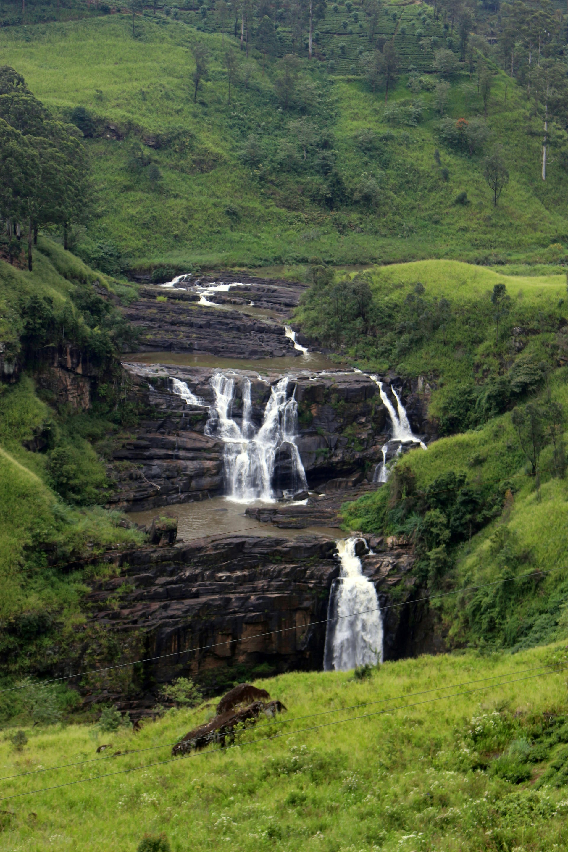 St. Clair's Falls cascading through lush green tea estate hills