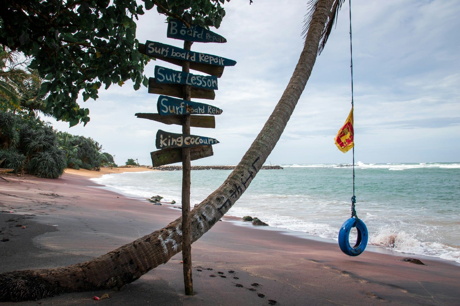 Surf school signpost on beach with Sri Lanka flag — Arugam Bay
