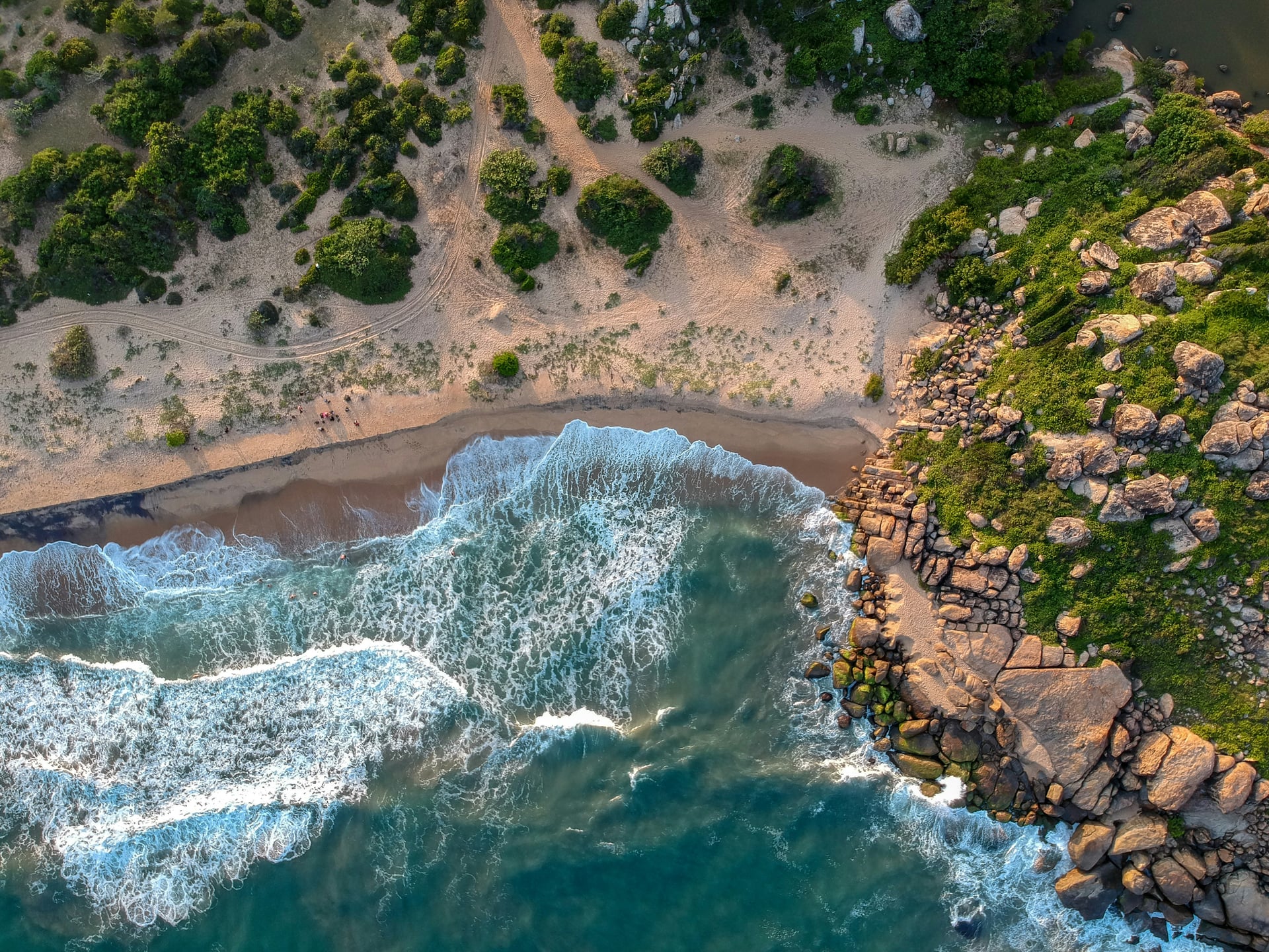 Aerial view of rocky Sri Lanka coastline with breaking ocean waves