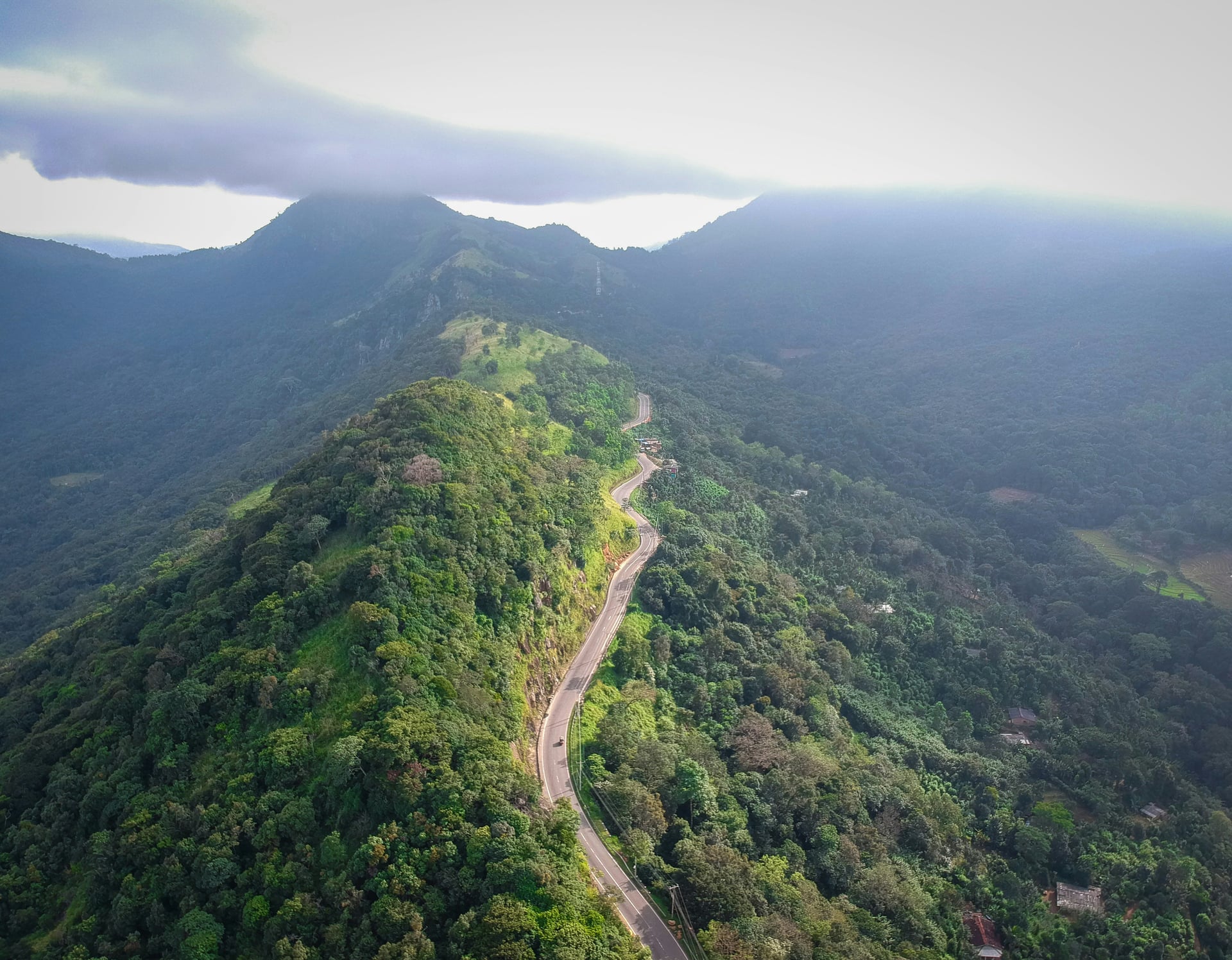 Aerial view of winding mountain road through lush green Sri Lanka hill country