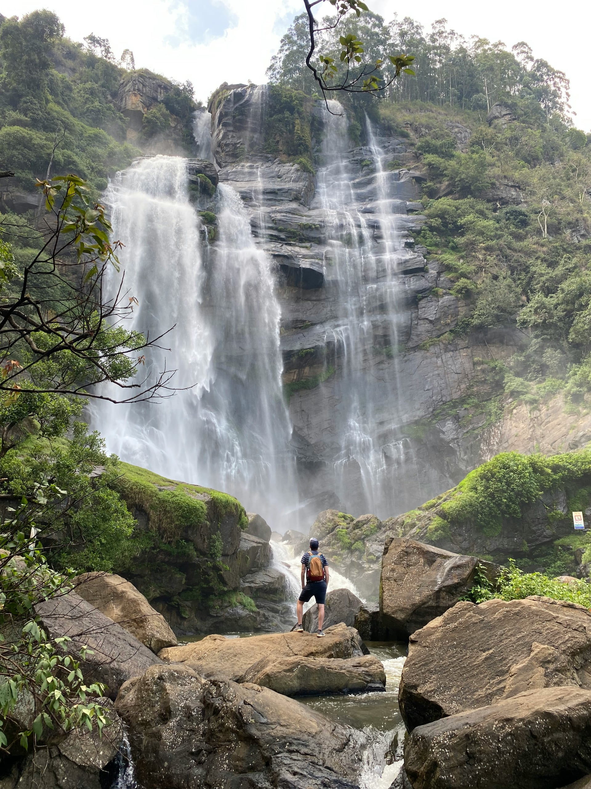 Hiker standing at the base of Bambarakanda Falls — Sri Lanka's tallest waterfall