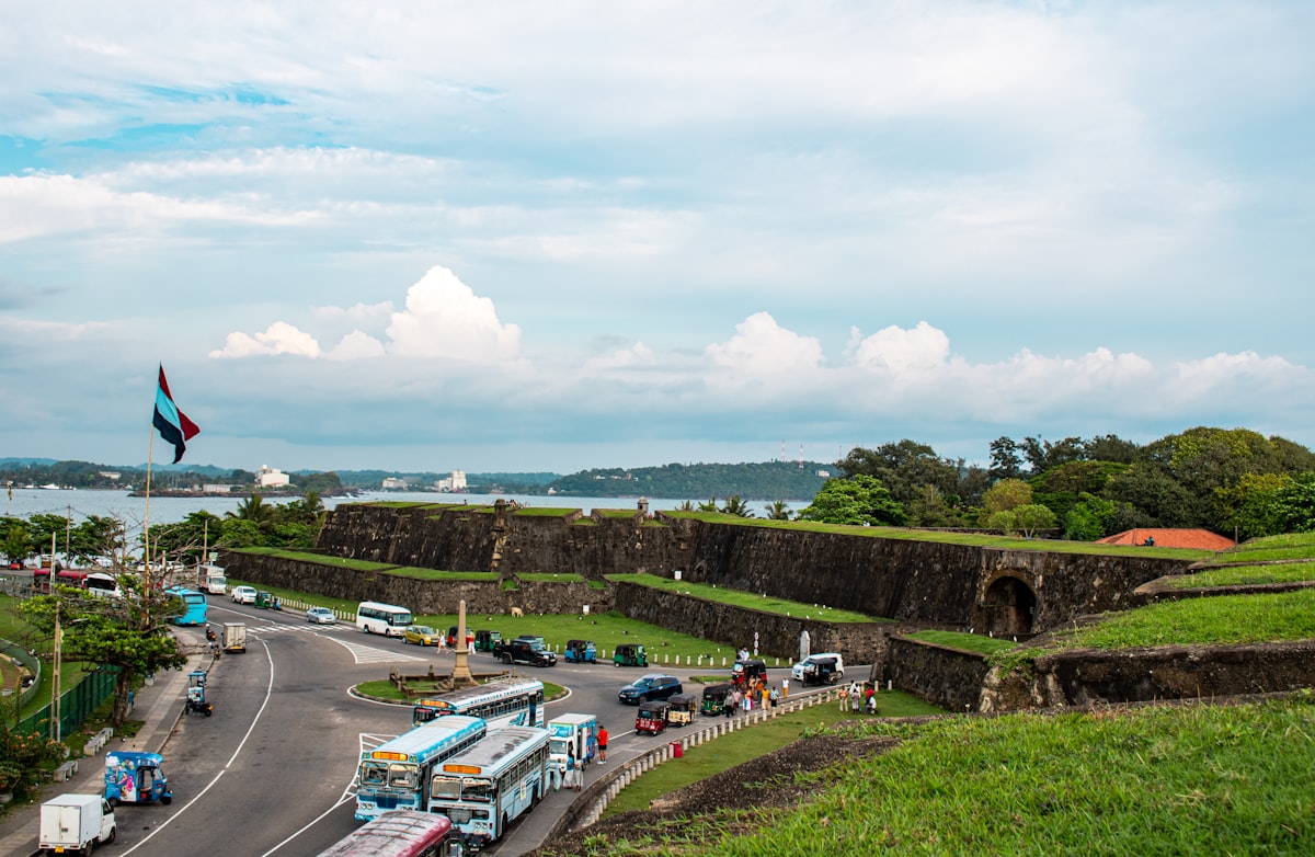 Galle Fort entrance with traffic circle, buses and tuk-tuks beside the massive ramparts
