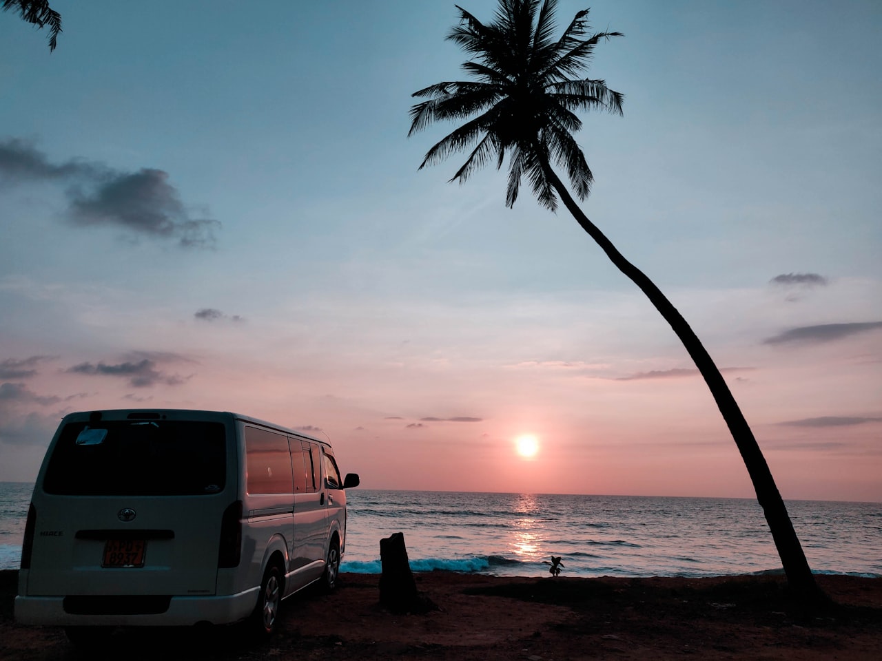 Golden sand beach at Hikkaduwa with turquoise waves rolling in and palm trees lining the shore