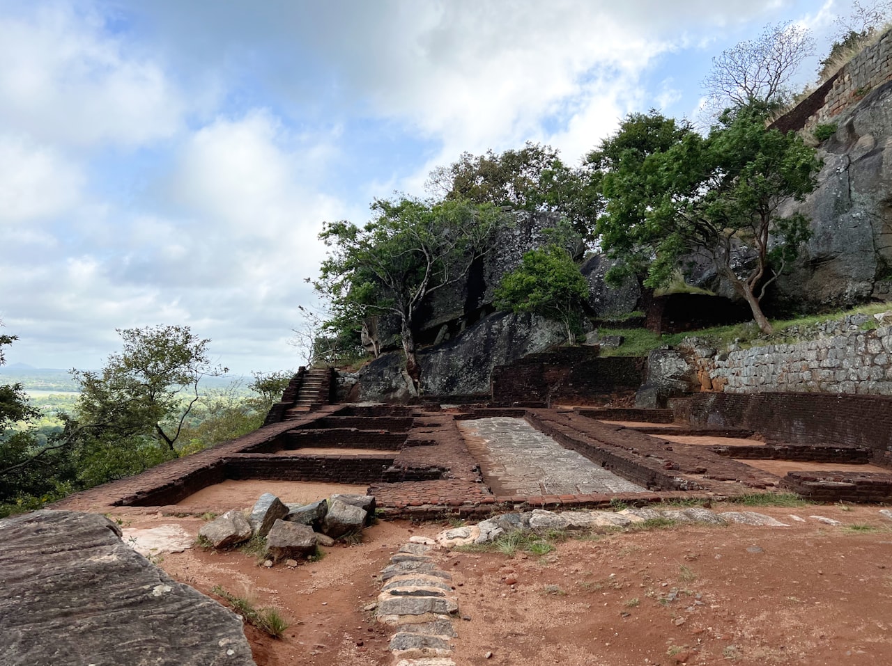 Ancient stone ruins of Ritigala monastery emerging through dense tropical forest
