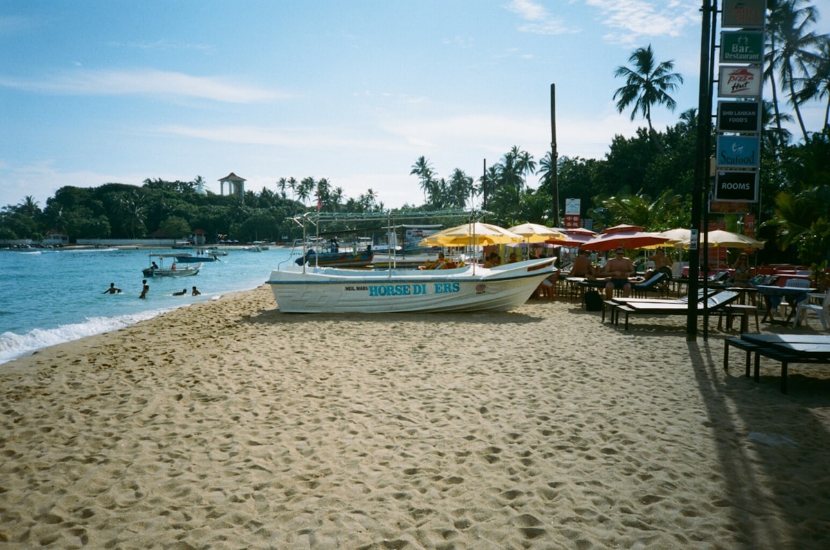 The curved golden bay of Unawatuna Beach with turquoise waters and palm-fringed shoreline